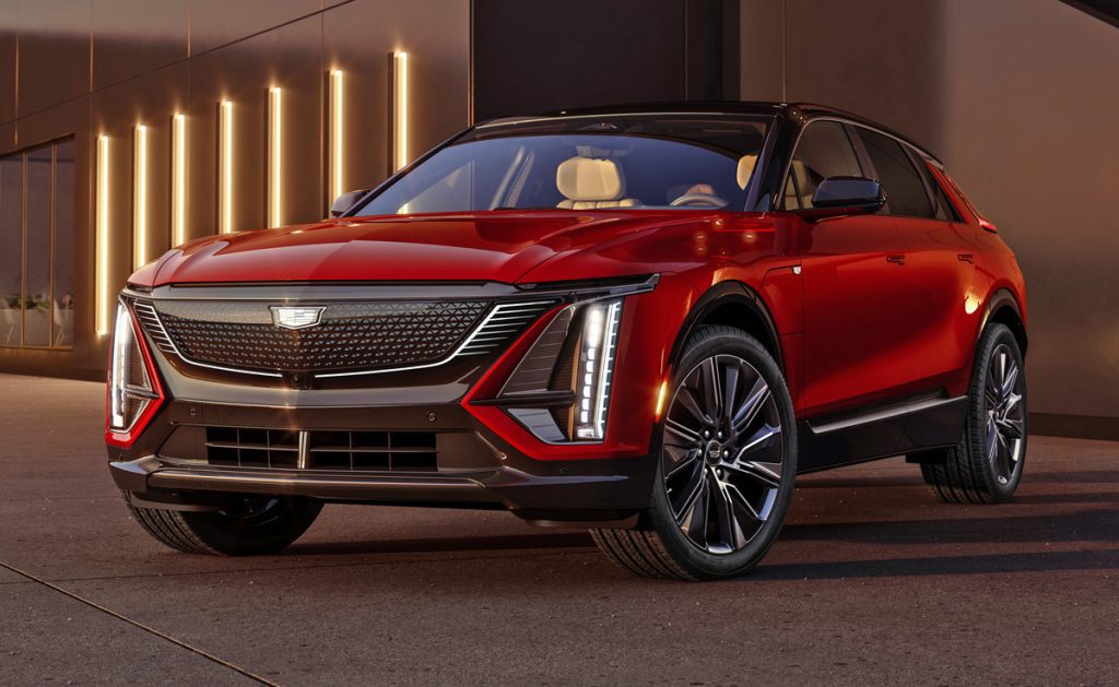 Front driver’s side 3/4 view of the 2024 Cadillac LYRIQ Sport trim with front grille illuminated.