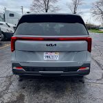 2025 Kia Carnival Hybrid SX Prestige rear view, Ceramic Silver, truck stop