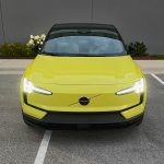 2025 Volvo EX30 in Moss Yellow, front end, headlights on
