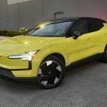 2025 Volvo EX30 in Moss Yellow, front 3/4 view, night time,