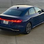 2025 Audi S5 in Ascari Blue, rear 3/4 view, taillights on,