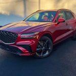 2026 Genesis GV70 Sport Prestige in Mauna Red, front 3/4 view,