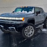 2026 GMC Hummer Pickup in Meteorite Metallic, front 3/4 view, lights on,