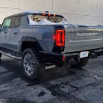 2026 GMC Hummer Pickup in Meteorite Metallic, rear 3/4 view, lights on,