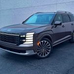 2026 Hyundai Palisade Hybrid in Cast Iron Brown, front 3/4 view, headlights on,