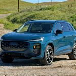 2026 Audi Q3 in Malpelo Blue metallic, front 3/4 view, dirt road,