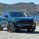 2026 Audi Q3 in Malpelo Blue metallic, near lake, lights on,