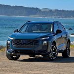 2026 Audi Q3 in Malpelo Blue, on beach, front 3/4 view,