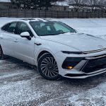 2026 Hyundai Sonata Hybrid Limited in Serenity White, front 3/4 view, lights on,