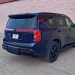 2026 Nissan Armada PRO-4X in Deep Ocean Blue Pearl, rear 3/4 view, taillights on,
