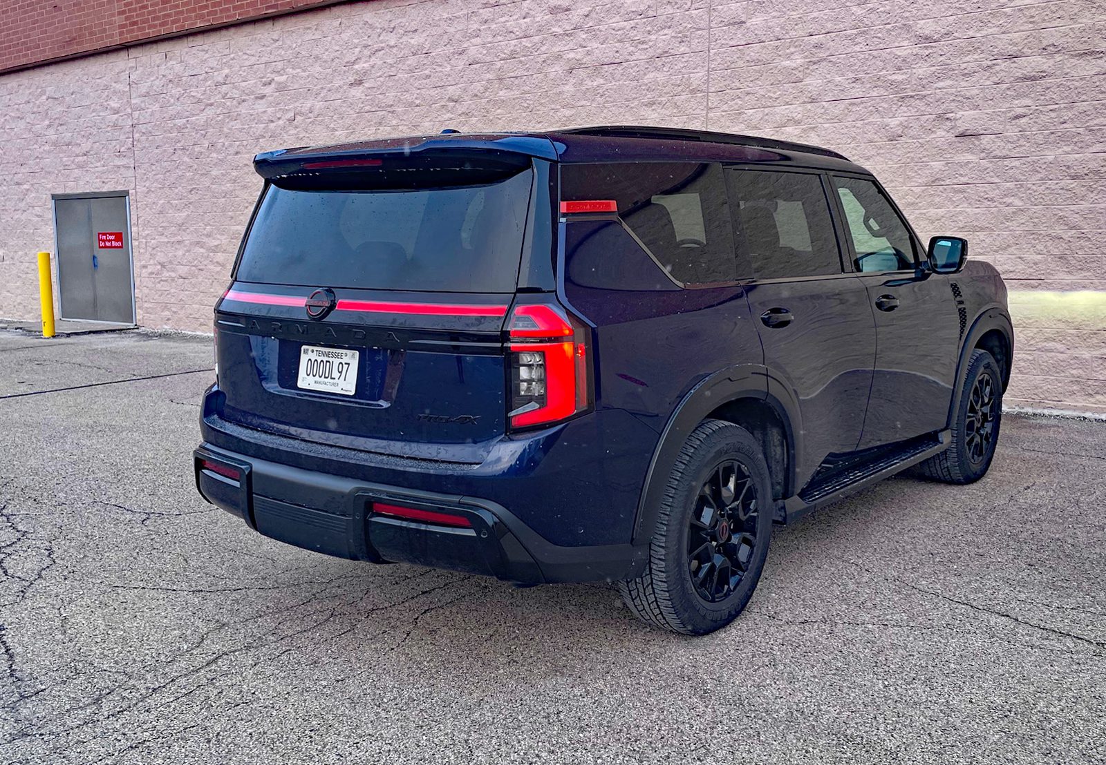 2026 Nissan Armada PRO-4X in Deep Ocean Blue Pearl, rear 3/4 view, taillights on,