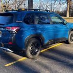 2026 Subaru Forester Wilderness in Geyser Blue, rear 3/4 view, trees