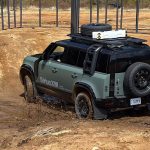 2026 Land Rover Defender Trophy Edition, blue, rear 3/4 view, off-road,