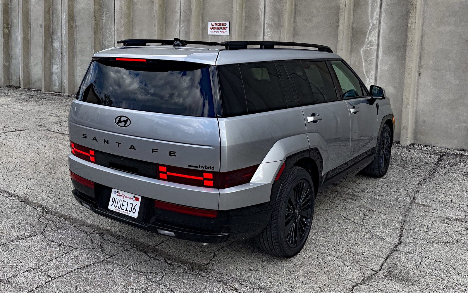 Hyundai Santa Fe Hybrid Calligraphy in Shimmering Silver, rear 3/4 view, taillights on,