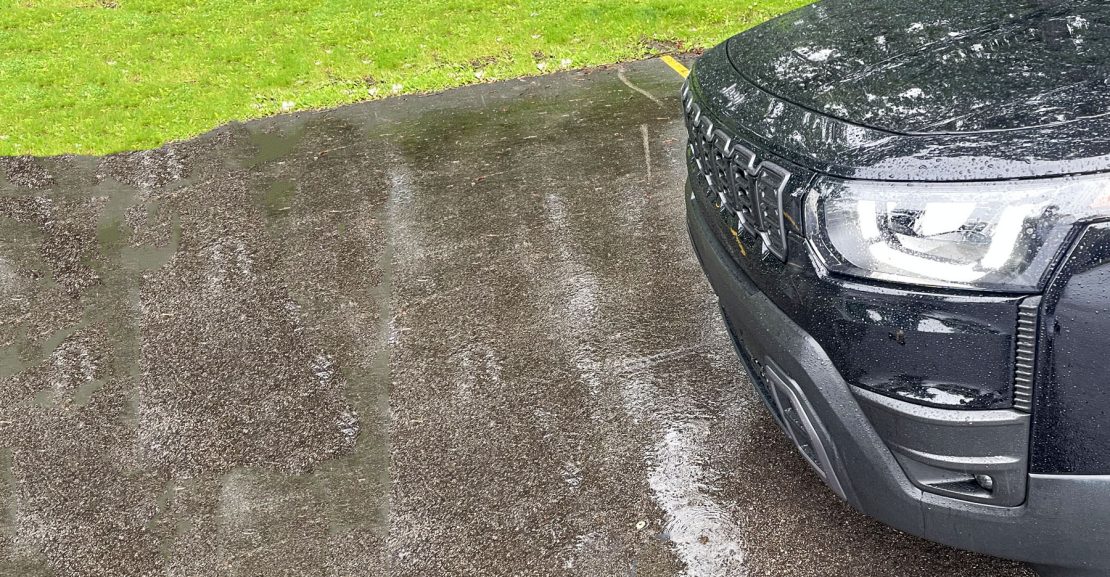 2026 Jeep Cherokee Laredo in Diamond Black Crystal, front clip, rain, headlights on,