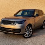 2026 Land Rover Range Rover SE in Batumi Gold, front 3/4 view, magic hour, sunset,