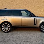 2026 Land Rover Range Rover SE in Batumi Gold, profile view, magic hour, sunset,