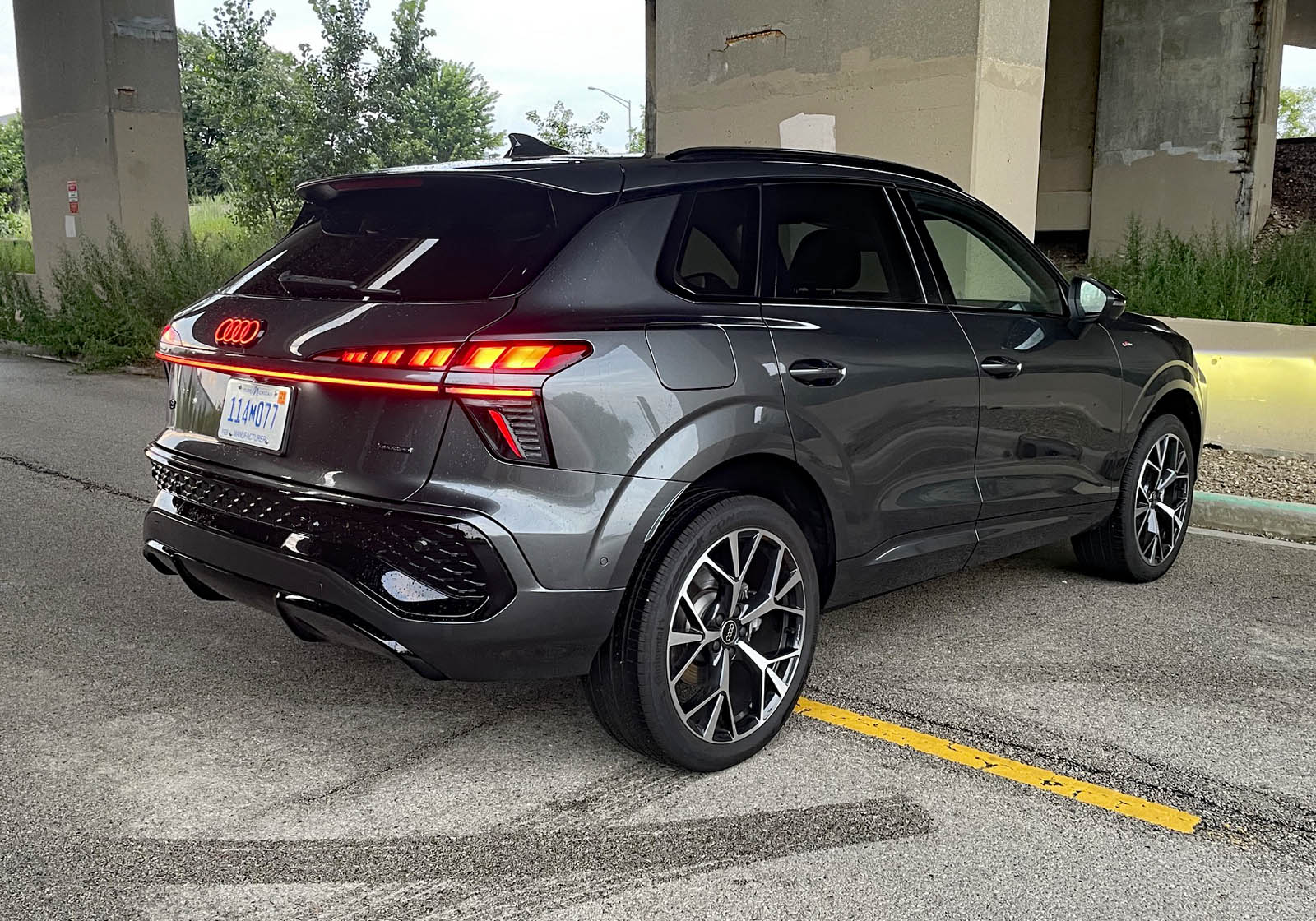 2026 Audi Q3 S Line in Daytona Gray Pearl, rear 3/4 industrial, taillights on