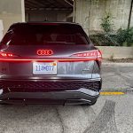 2026 Audi Q3 S Line in Daytona Gray Pearl, rear view, taillights on, concrete background,