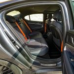 2026 Genesis G70 3.3T Prestige Graphite in Ceres Blue, rear seat, passenger space, orange seat belts,