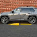 2026 Toyota RAV4 Woodland PHEV in Urban Rock, profile, red brick wall,