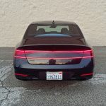2026 Genesis G90 Prestige Black, rear view, taillights on, white wall,