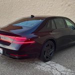 2026 Genesis G90 Prestige Black, rear 3/4 view, taillights on,